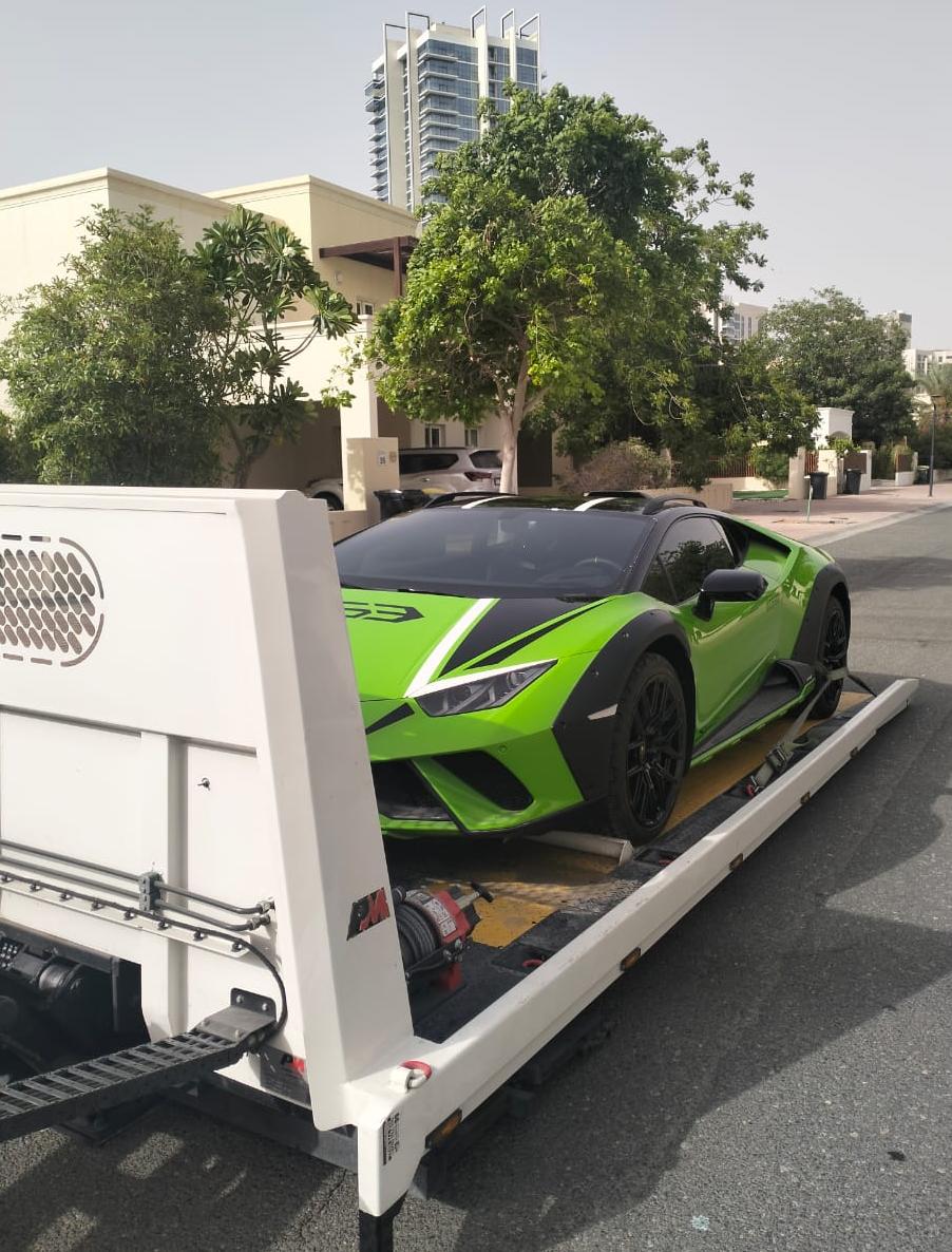 Flatbed tow truck transporting a luxury vehicle in Dubai